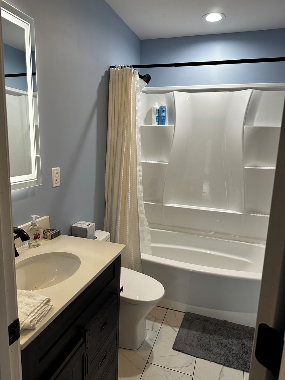 Main level guest bathroom w/ lighted mirror