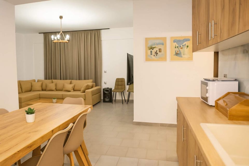  Fully Equipped Kitchen and Dining Area – Modern kitchen with full-size fridge, oven, stovetop, and ample storage, alongside a wooden dining table for shared meals.