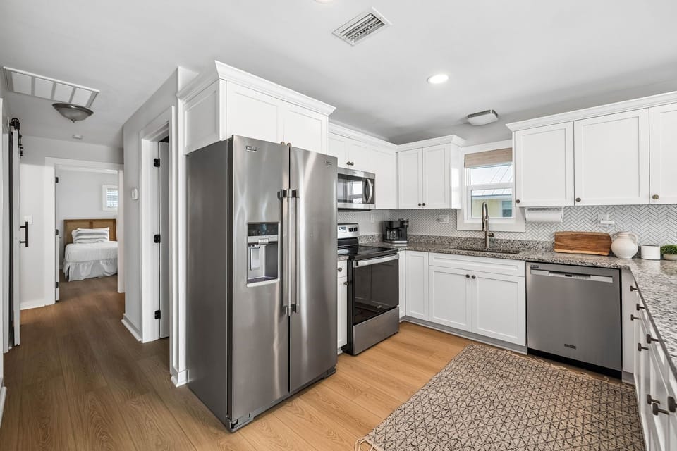 Bright, fully-equipped kitchen with modern stainless appliances, granite countertops, and everything you need for your home-away-from-home cooking experience.