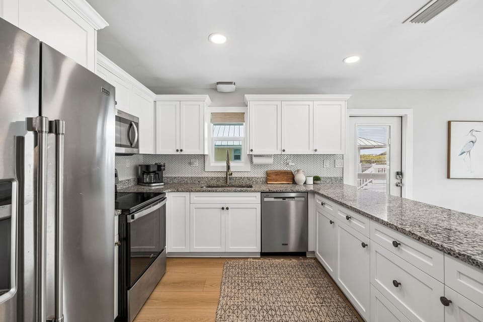 Bright, fully equipped kitchen with sleek granite countertops and stainless steel appliances—perfect for preparing your morning coffee or a family meal during your stay.