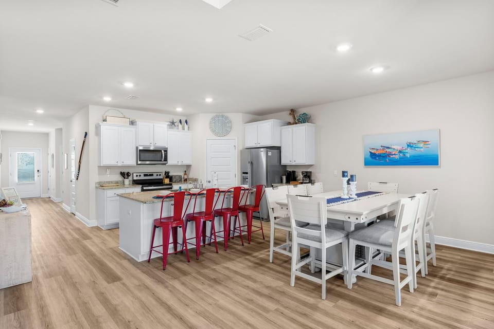 Your bright, open-concept kitchen flows seamlessly into the dining area, where you'll gather around the spacious table for memorable meals together.