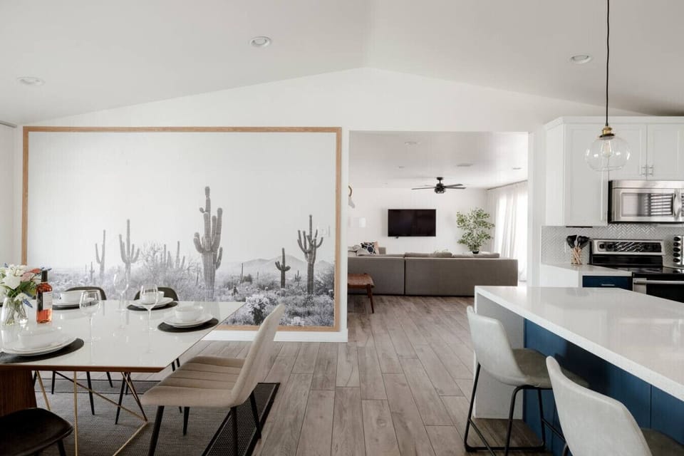 Stylish dining area with desert-inspired mural, open to living room and kitchen