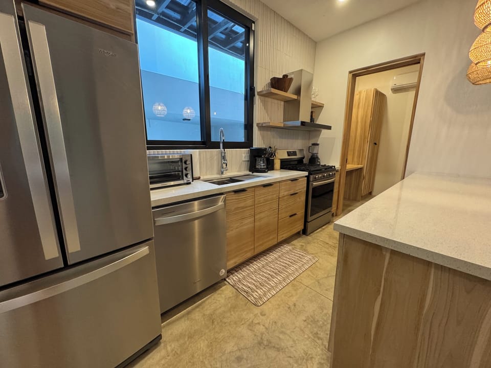 Full kitchen with stainless steel appliances and breakfast counter for four