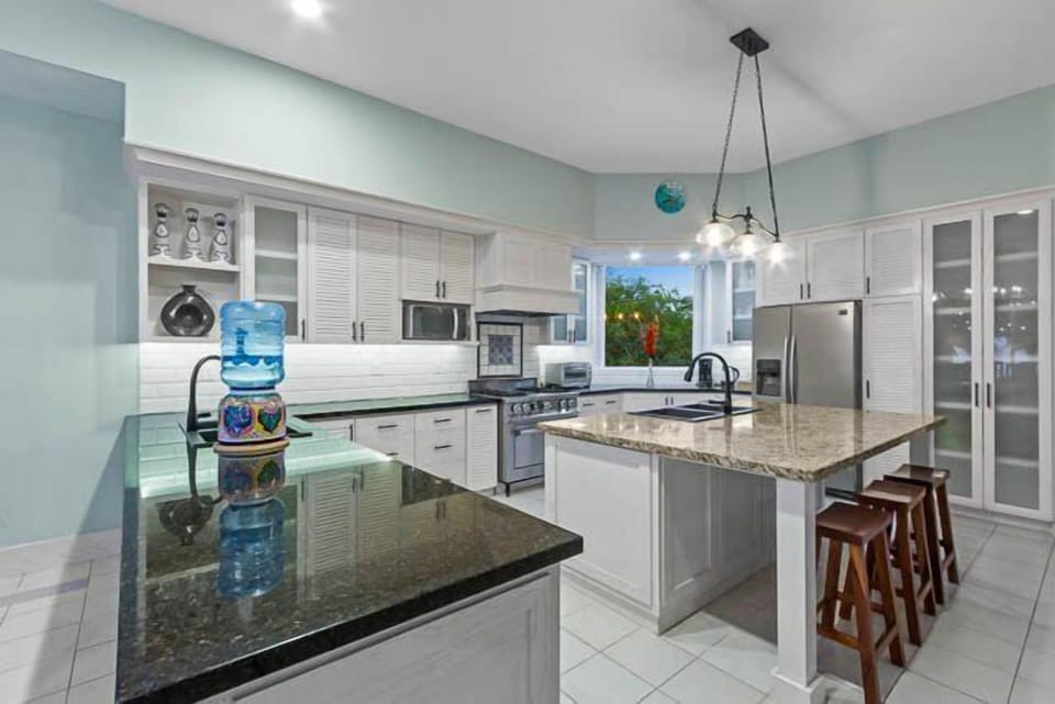 The huge open kitchen is fully equipped with two sinks and an oversized fridge.
