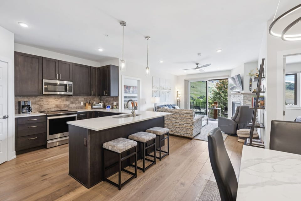 Full kitchen and bar on island with seating for 3 people.