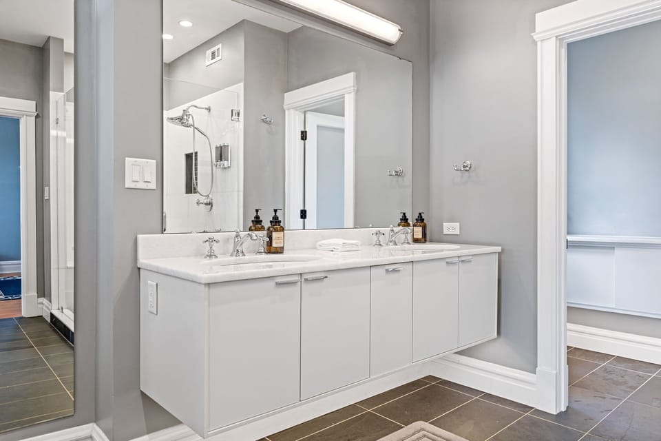 Bedroom 1's ensuite bathroom includes a bright double-sink vanity with generous storage.