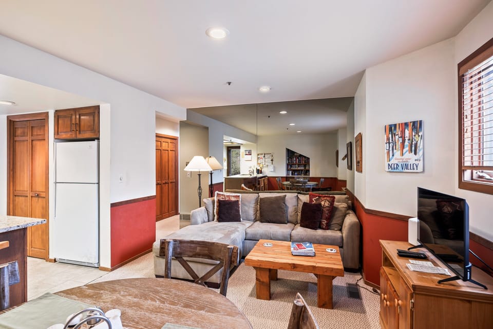- Downstairs living room with sectional sofa and TV setup  
- Open concept connects to dining and kitchen spaces  
- Comfortable area for families to relax after adventures