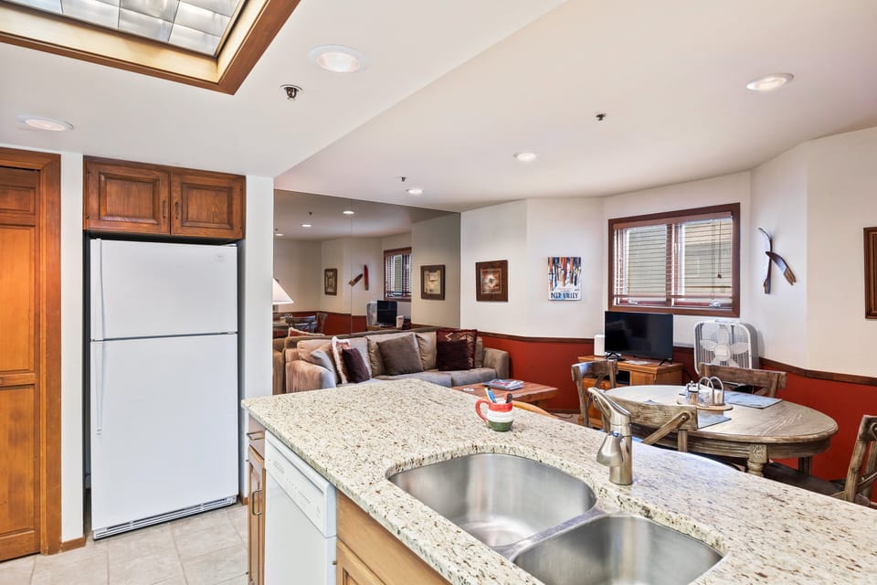 - Kitchen with granite counters and wood cabinetry design  
- Open layout flows into dining and living room seating  
- Perfect for cooking meals after skiing or mountain hikes