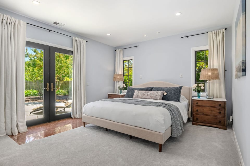 Spacious primary suite with sitting area, en-suite bathroom, walk-in closet and patio doors