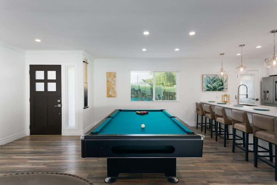 Living area featuring designer furnishings, a Smart TV, pool table, and access to the backyard.