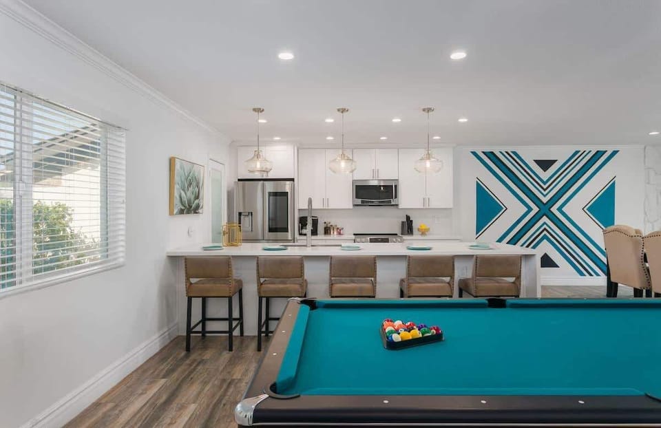 Living area featuring designer furnishings, a Smart TV, pool table, and access to the backyard.