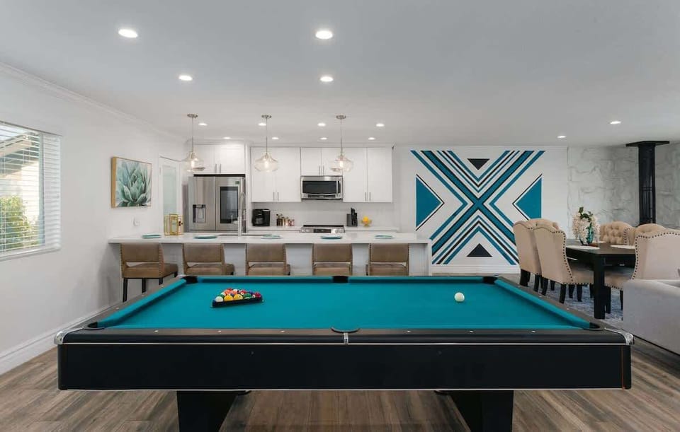 Living area featuring designer furnishings, a Smart TV, pool table, and access to the backyard.