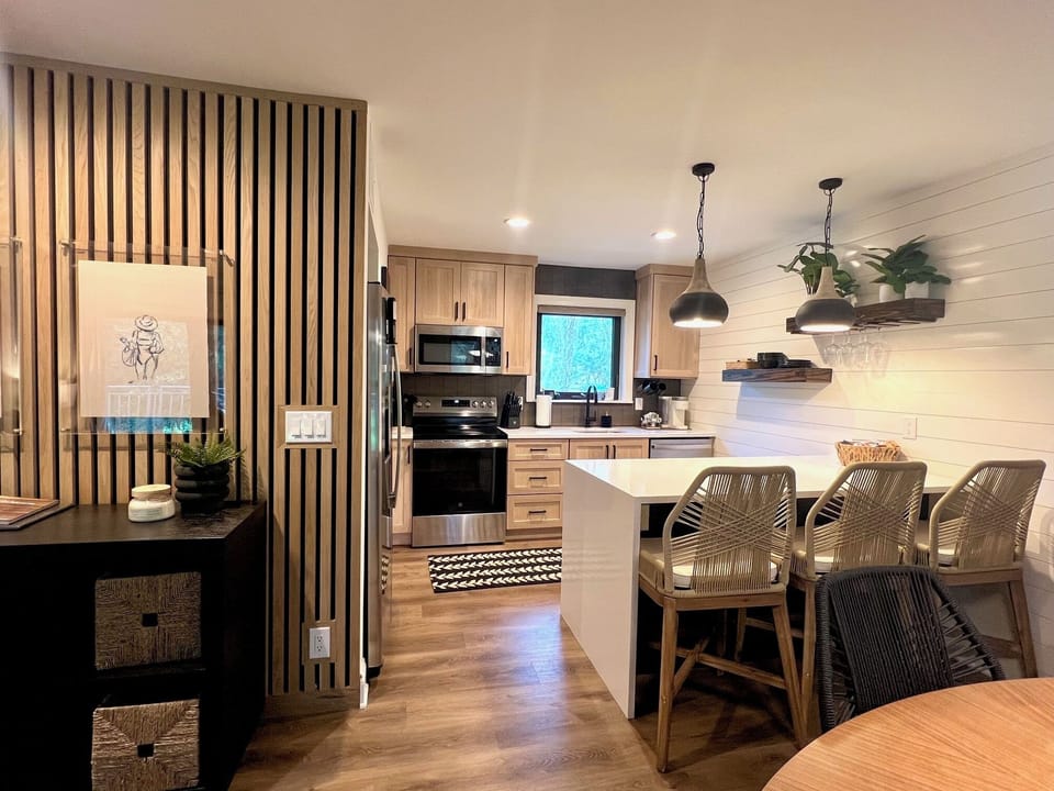 Cook with ease in this bright, modern kitchen featuring sleek stainless steel appliances, a Keurig for your morning caffeine fix, and a stylish breakfast bar for casual dining.