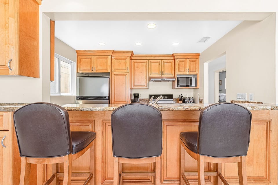 The breakfast counter includes bar stool seating.
                