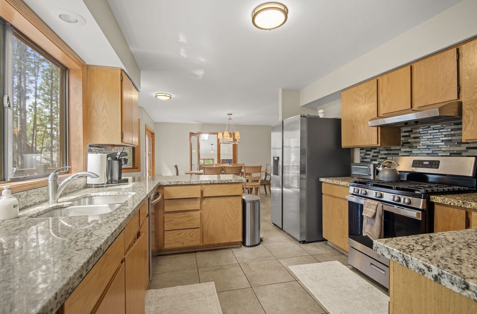 View of the breakfast table, Gas stove, sink, refrigerator and ice machine.  
