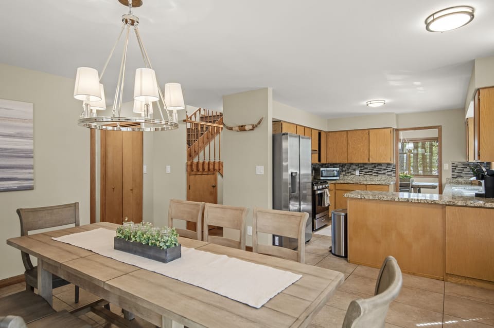 Breakfast table and kitchen. View of hallway leading to the stairs. 