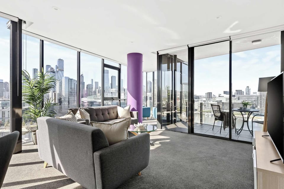 Unwind in a spacious living area with two plush 3-seater sofas and two inviting armchairs, all set against breathtaking panoramic harbour views.