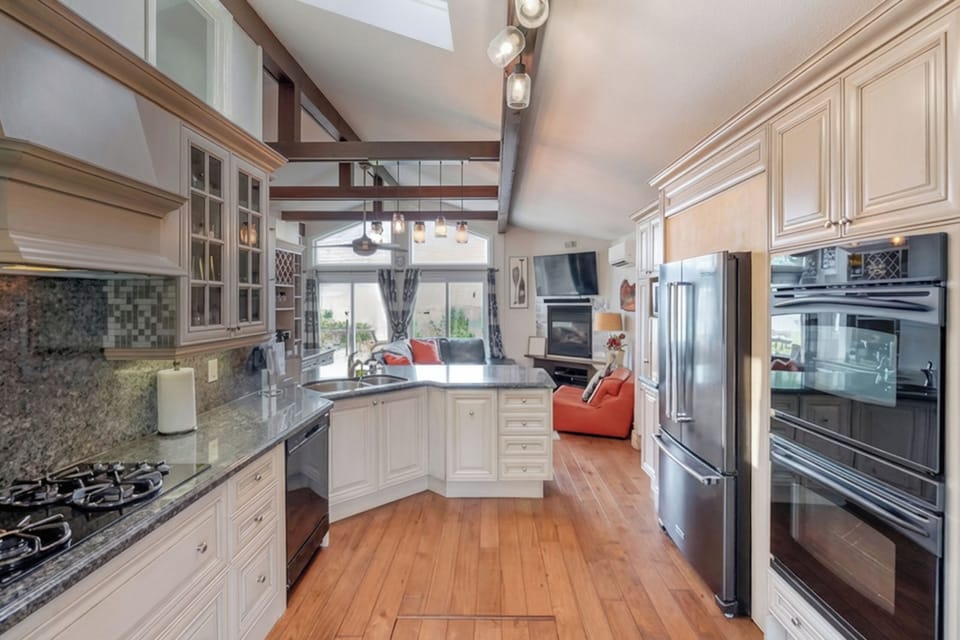 An open-concept kitchen flows into the living space with vaulted ceilings and natural light. Designed for gathering and relaxed vacation living.