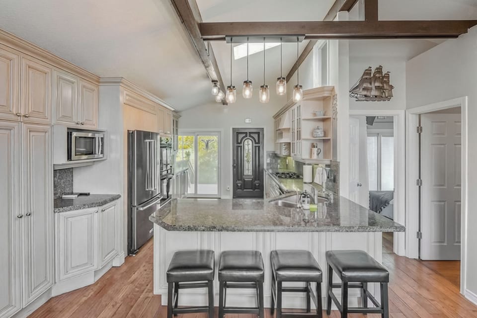 Island seating with open sightlines to the living area and deck access. Ideal for family meals and seamless indoor-outdoor travel.