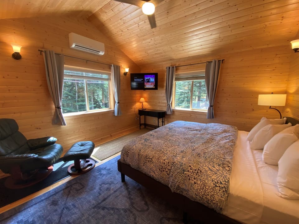 Beautiful pine paneling inside and forest views outside are enjoyed in this retreat bedroom.