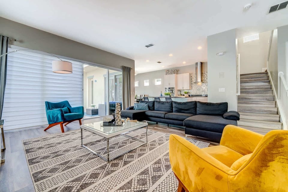 Modern living room with colorful seating and natural light from large sliding doors.