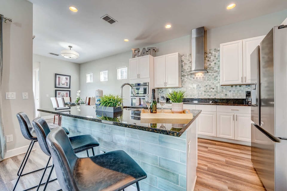 Modern kitchen with a granite countertop island and bar seating for casual dining.