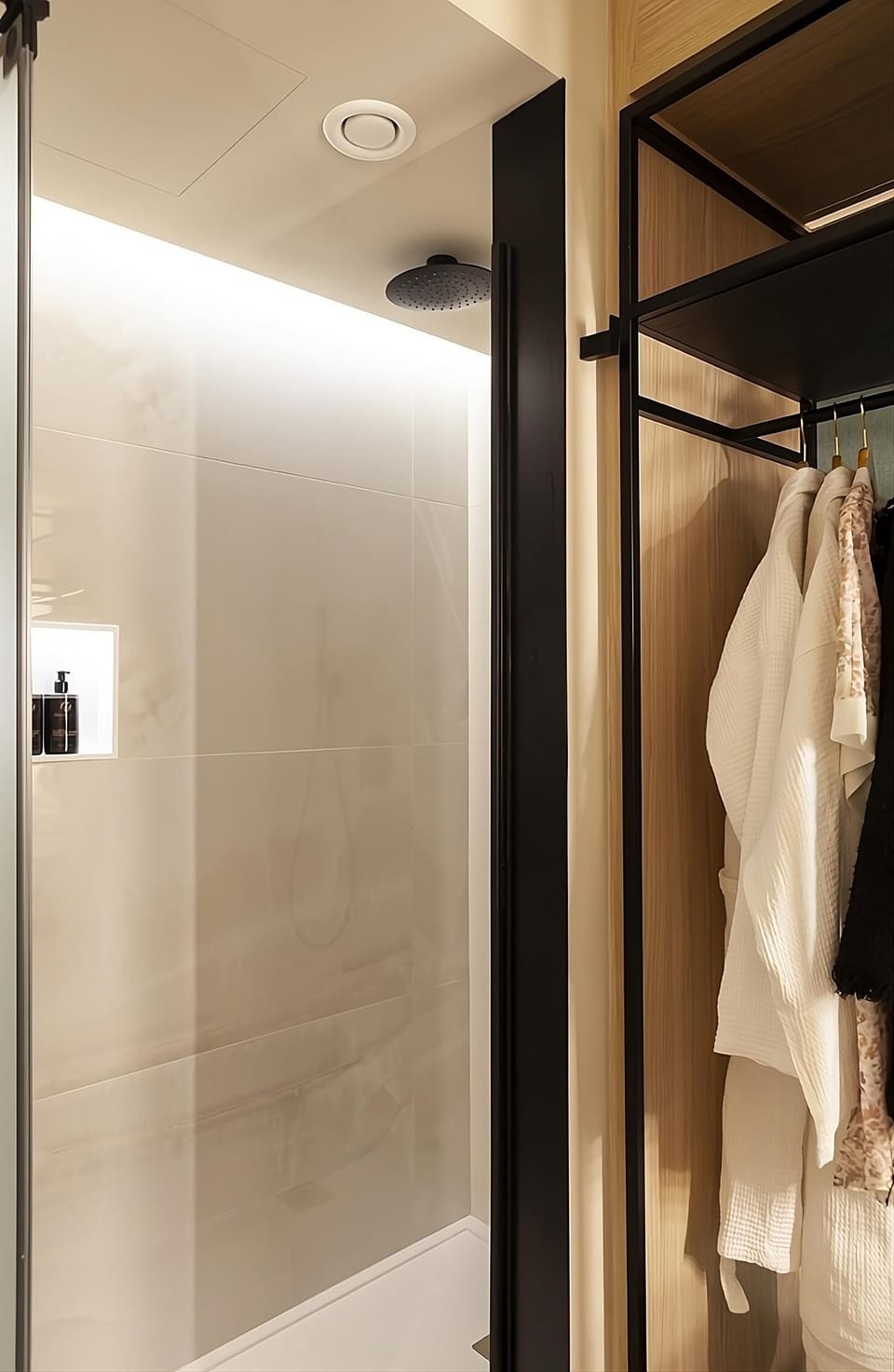 Rinse off under a rainfall shower, robes ready beside you.