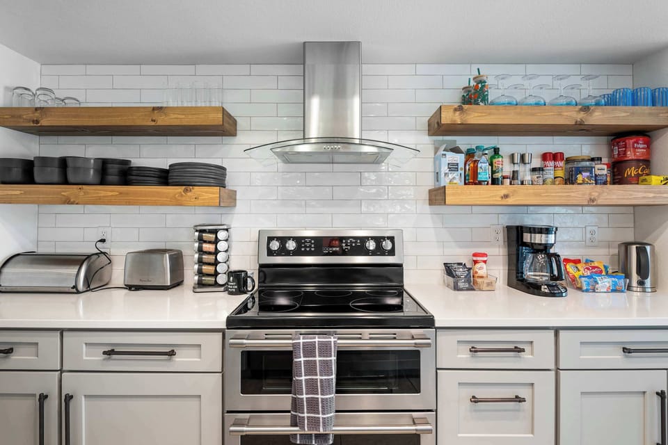 Full kitchen with open shelves, a coffee station, and breakfast supplies ready to go.