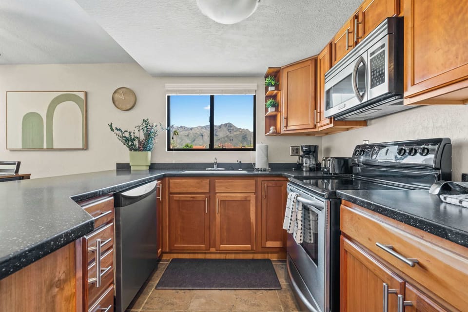 Cook with a view in this fully equipped kitchen featuring modern appliances, granite countertops, and a stunning mountain backdrop right from the window.