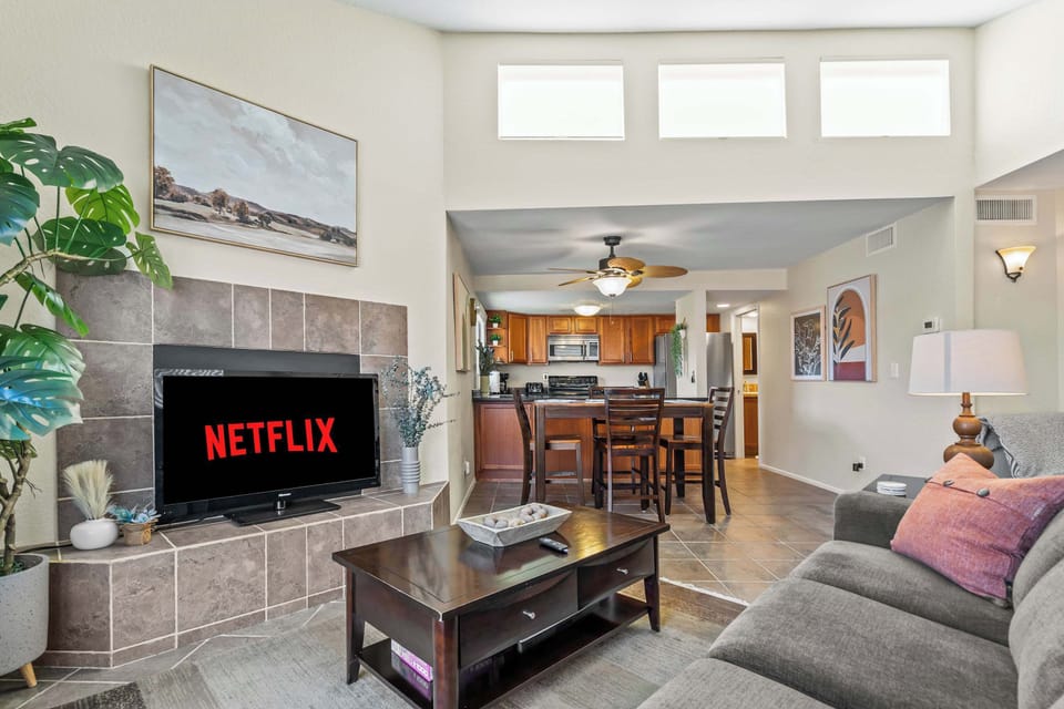 Unwind in this spacious, sun-filled living room featuring a cozy sectional, modern decor, and a smart TV, perfect for a relaxing night in after exploring the area.
