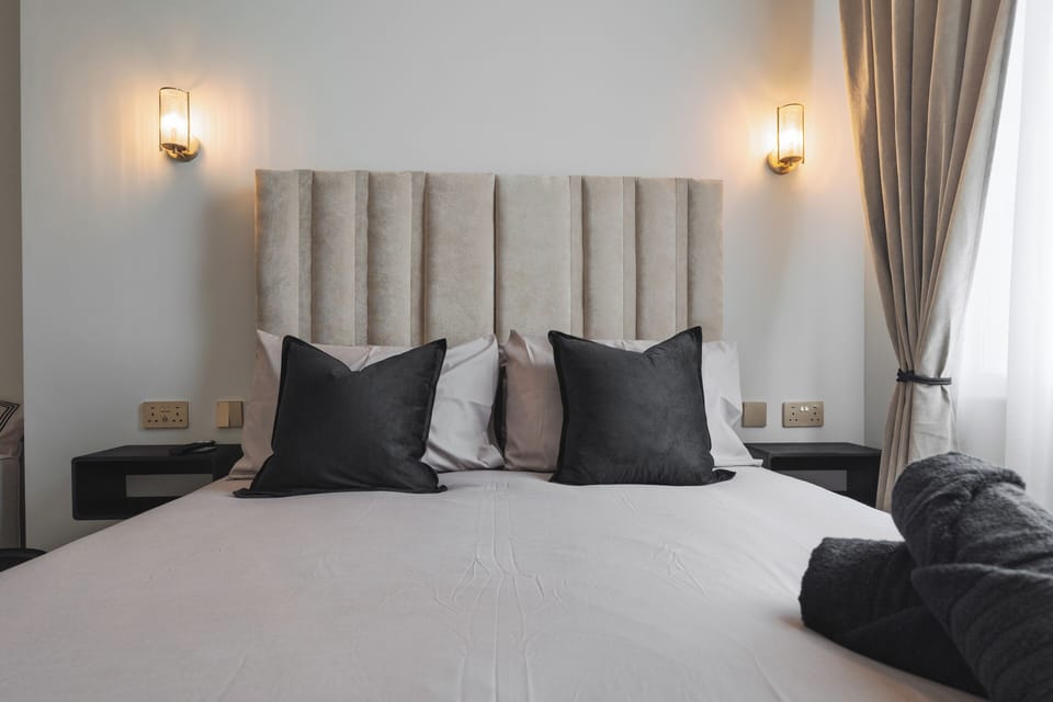 A bright, open-plan space featuring a comfortable double bed, sofa bed, vanity unit with mirror, Smart TV, and electric heater—perfect for relaxing or getting ready for a night out in the city. All bedding provided, inc. for sofa bed.