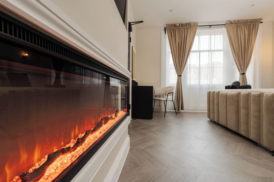 An electric fireplace adds a warm, inviting glow to the room—perfect for creating a cosy atmosphere at any time of day.
