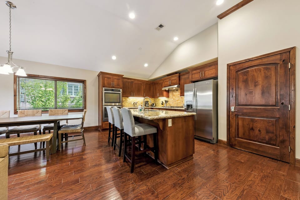 Your gourmet kitchen features rich wood cabinetry, granite counters, and a spacious island perfect for cooking memorable meals together.