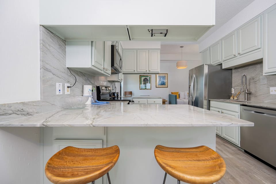 Kitchen featuring sleek stainless appliances and elegant marble countertops, perfect for culinary adventures