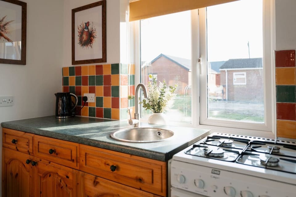Rustic charm meets colourful chaos! Cook up a storm with our vintage oven, sip tea with the ever-ready kettle, and enjoy pheasant art while the microwave watches over your snacks like a culinary lifeguard.