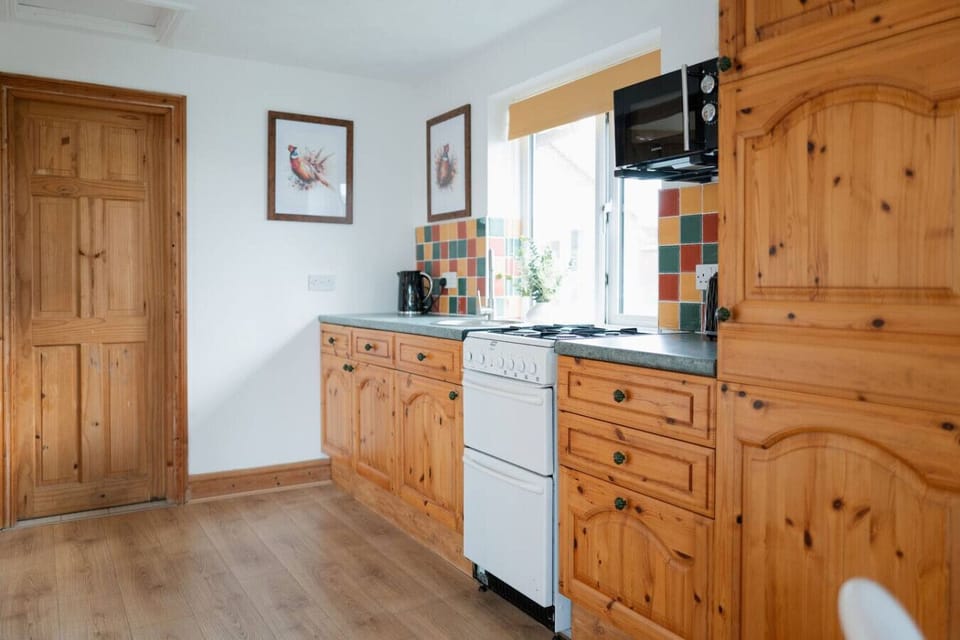 Rustic charm meets colourful chaos! Cook up a storm with our vintage oven, sip tea with the ever-ready kettle, and enjoy pheasant art while the microwave watches over your snacks like a culinary lifeguard.
