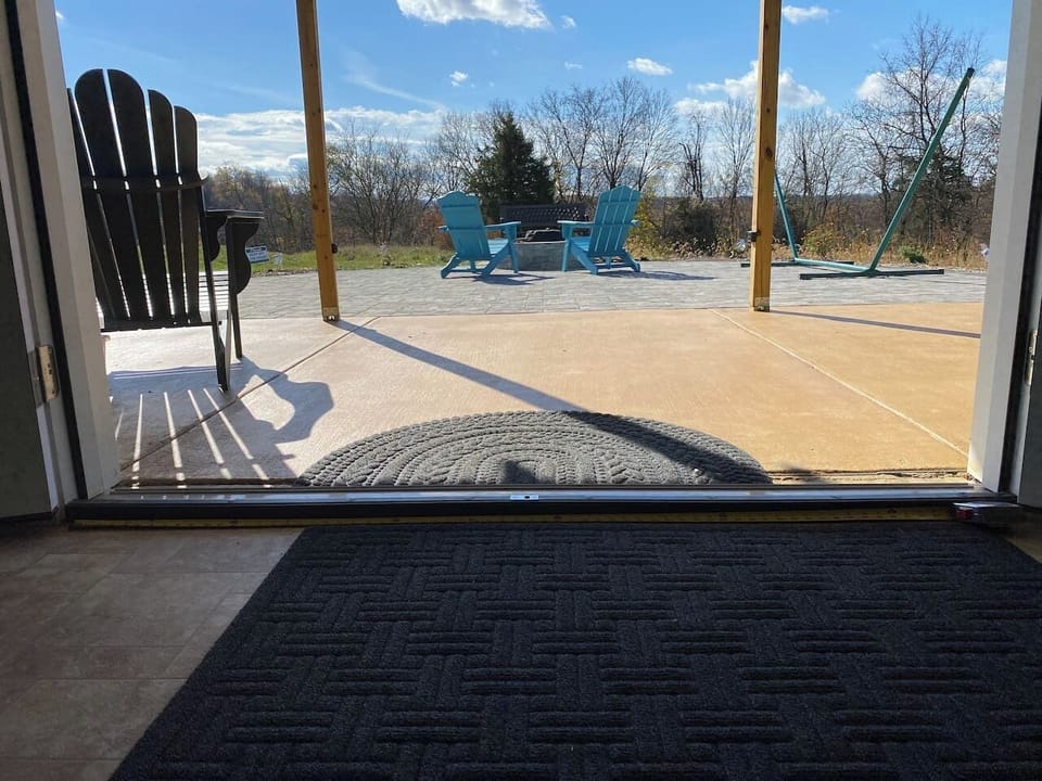 Exit to paver patio with view of chairs by fire pit