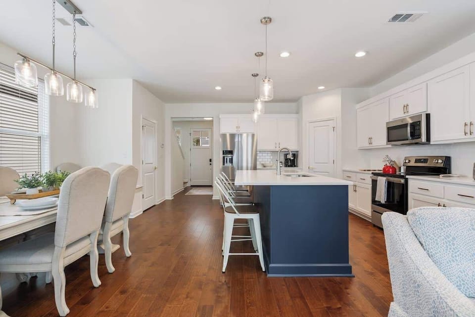 Sleek kitchen w/ island seating, pendant lighting & open layout