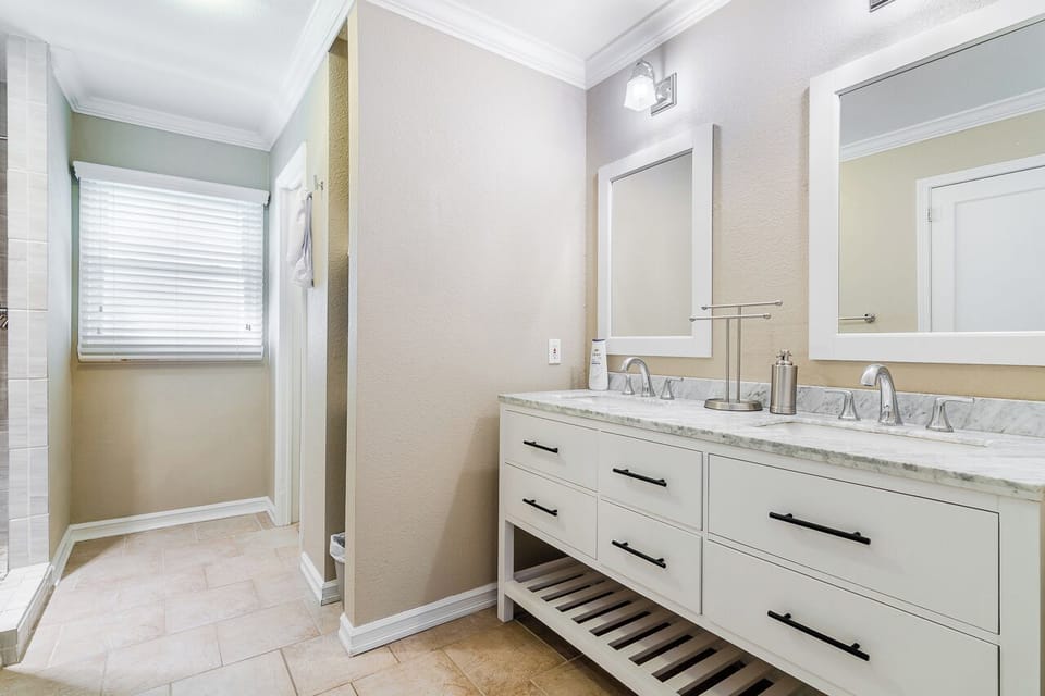 Primary attached bathroom with dual vanity sink and walk-in shower