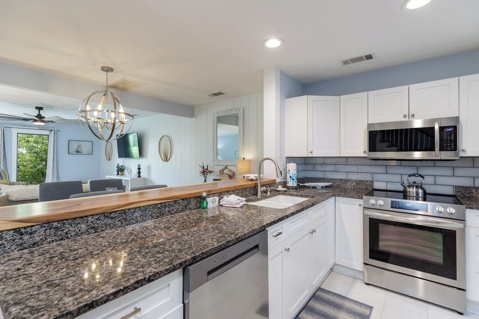 Sleek kitchen with granite countertops and open view to the living area.