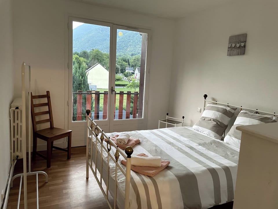 Main double bedroom with French doors to balcony, with views to gardens and mountains