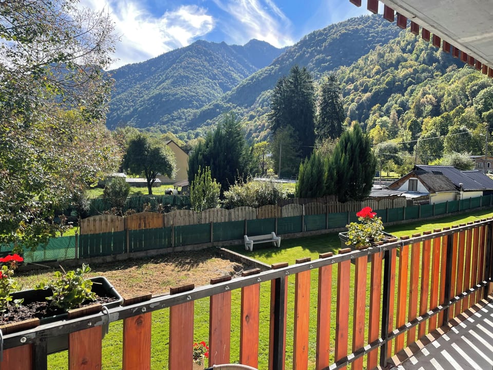 View of gardens and mountains from front balcony of sitting room and bedroom with 4-poster bed