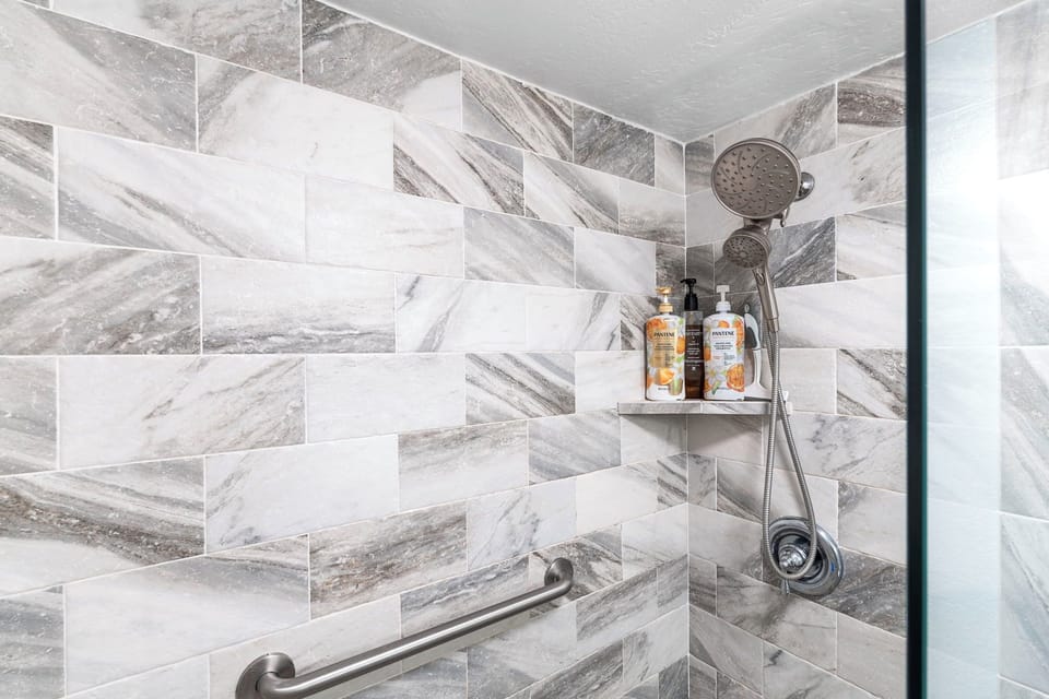 A well-maintained bathroom offering a walk-in shower, updated lighting, and all the essentials for your convenience.