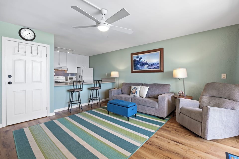 A welcoming living space with plush seating, A/C, natural light, and direct access to the lanai, all while enjoying tranquil ocean views from your sofa.
