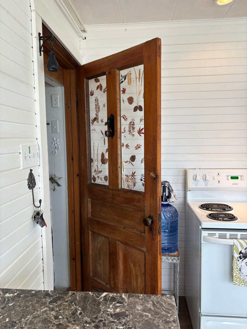 Vintage wooden door with nature-inspired panels adds cottage character.