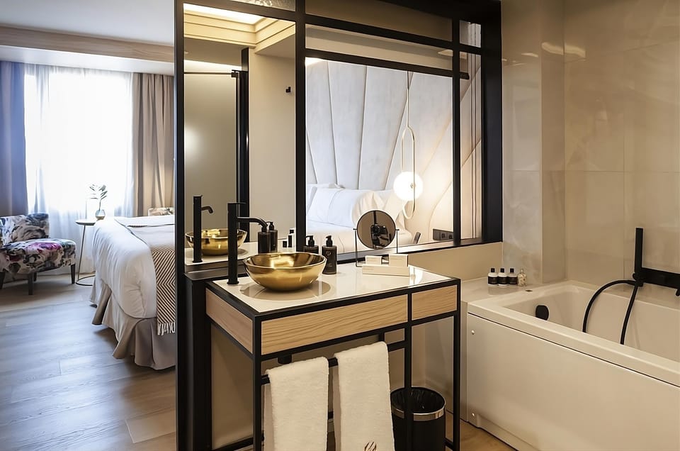 Refresh with a deep soak beside a striking modern vanity.