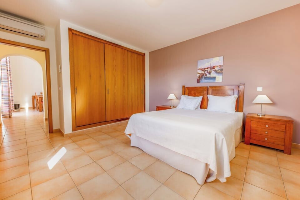 Settle into a spacious bedroom with warm wood tones.