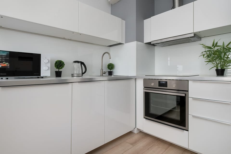 The modern kitchen with white cabinetry and a wooden countertop offers both functionality and style.