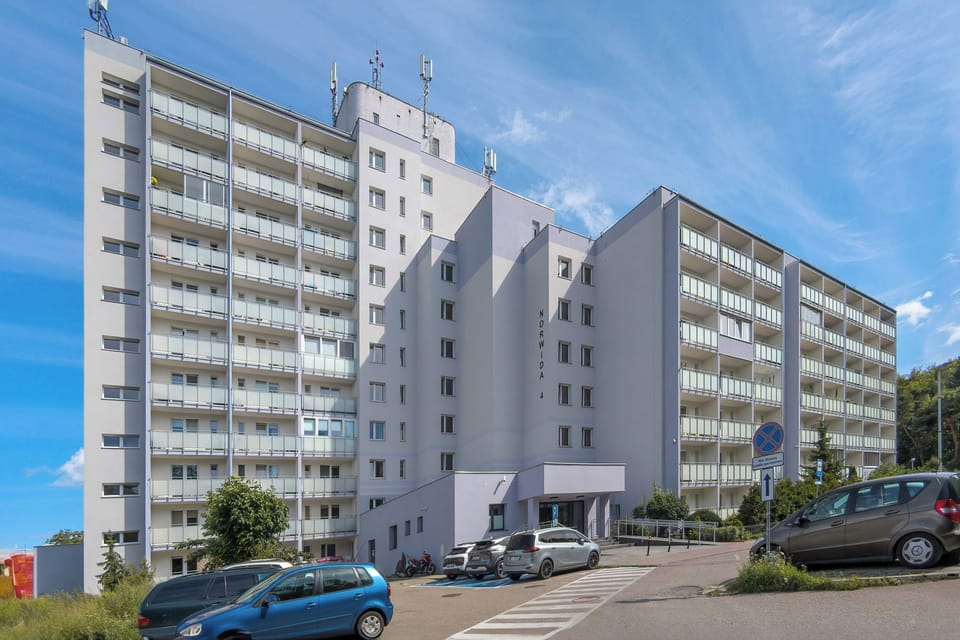 The building’s facade with a wide driveway and parking area offers convenient access for guests arriving by car.