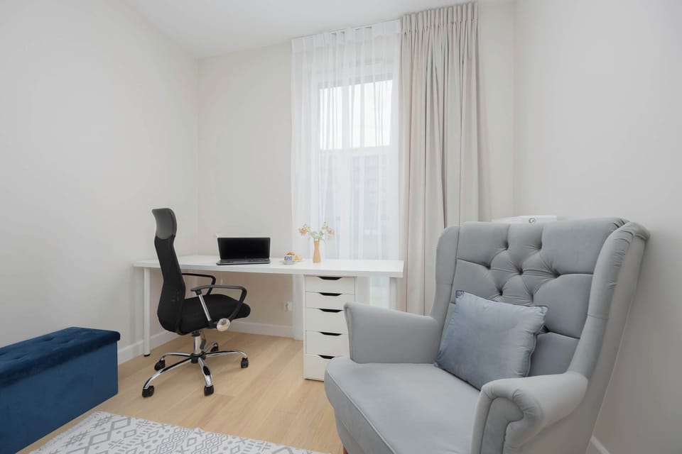 The bedroom with a desk and a comfortable armchair provides a quiet space, perfect for remote work or peaceful reading.